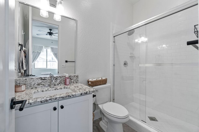 bathroom with toilet, ceiling fan, walk in shower, and vanity