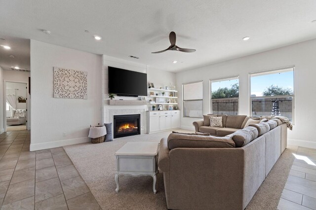 living room with ceiling fan, light tile patterned flooring, and built in shelves