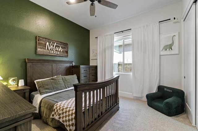 bedroom featuring ceiling fan, light colored carpet, and a closet