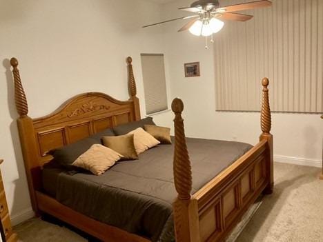 carpeted bedroom with ceiling fan and baseboards