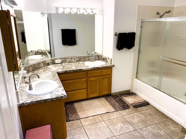 bathroom with double vanity, shower / bath combination with glass door, a sink, and tile patterned floors