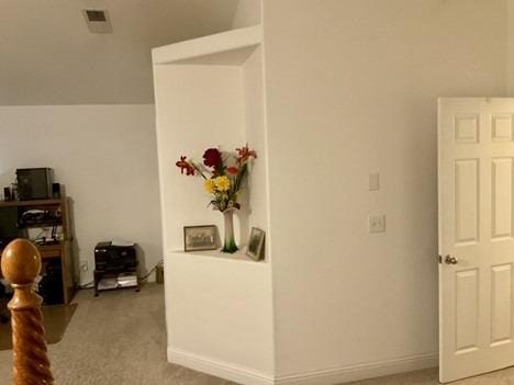 interior space featuring carpet flooring, visible vents, and baseboards