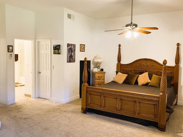 bedroom featuring connected bathroom, light carpet, a ceiling fan, visible vents, and baseboards