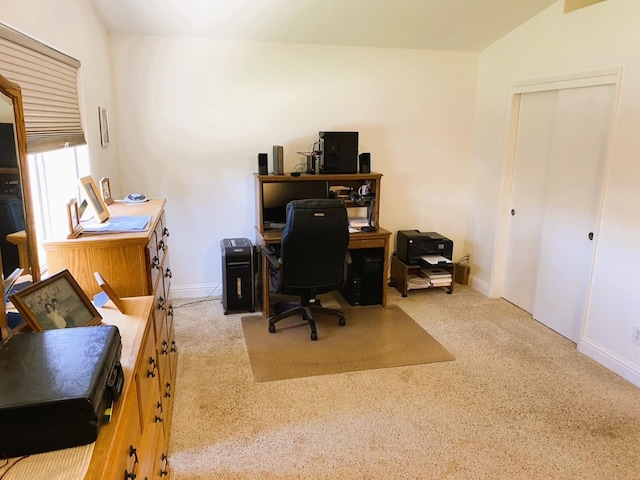 office featuring lofted ceiling, light colored carpet, and baseboards