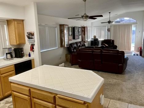 interior space featuring open floor plan, light tile patterned floors, a kitchen island, and light colored carpet