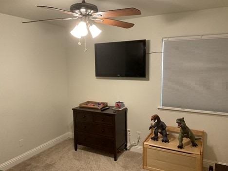 bedroom with a ceiling fan, light carpet, and baseboards