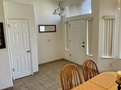 dining area with light tile patterned flooring, a chandelier, and plenty of natural light