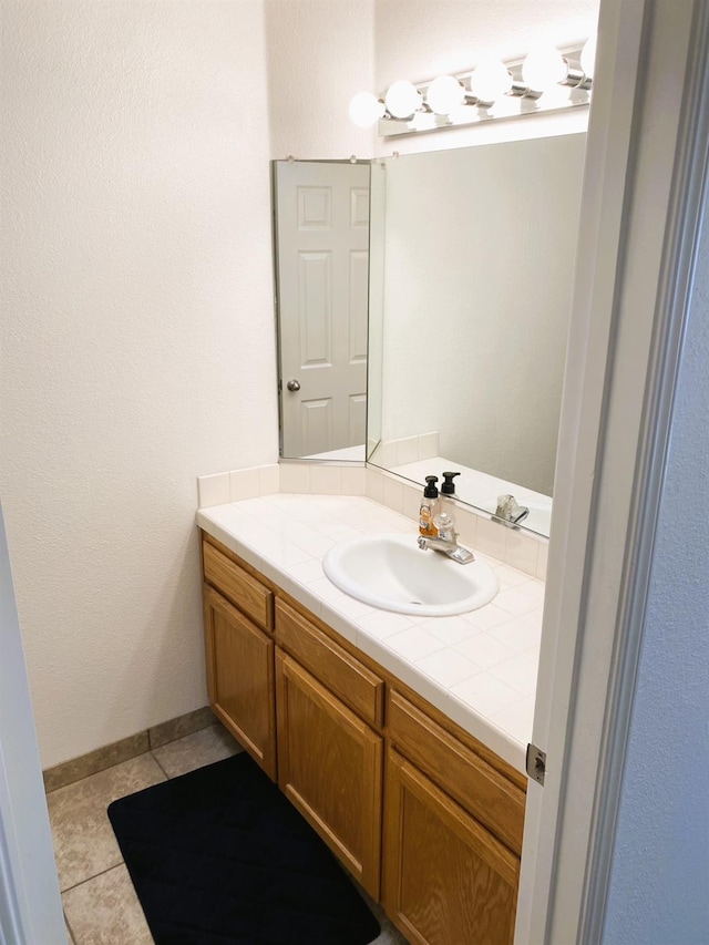 bathroom featuring vanity, baseboards, and tile patterned floors