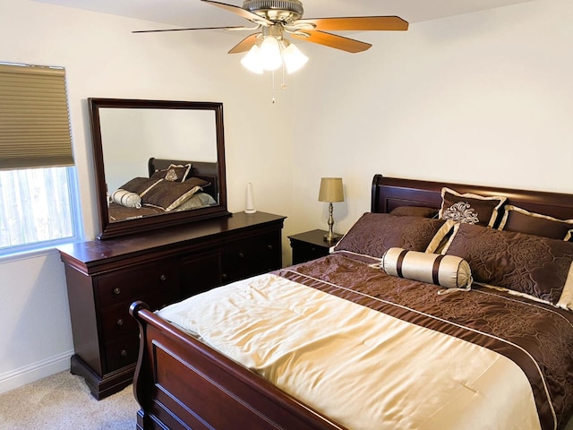 bedroom featuring light carpet, ceiling fan, and baseboards