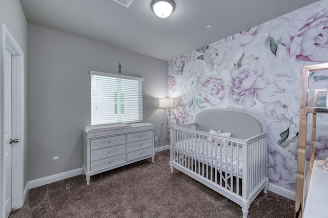 bedroom with a nursery area and dark carpet