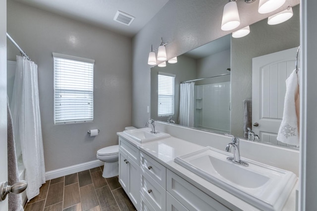 bathroom featuring toilet, vanity, and a wealth of natural light