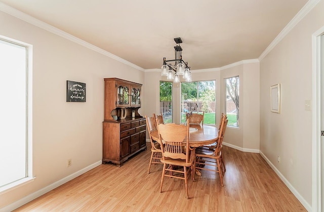 dining room with an inviting chandelier, ornamental molding, and light hardwood / wood-style flooring