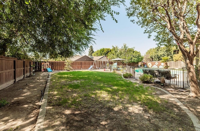 view of yard with a playground and a fenced in pool