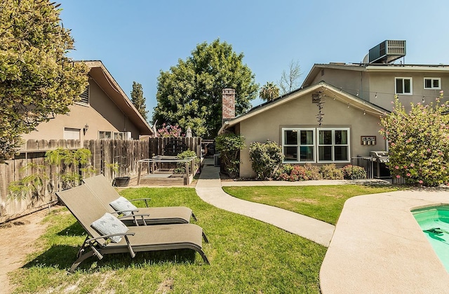 rear view of property with a yard and central AC