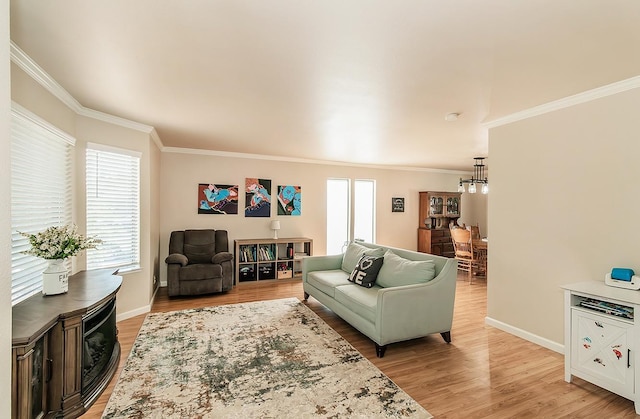 living room with ornamental molding and light hardwood / wood-style floors