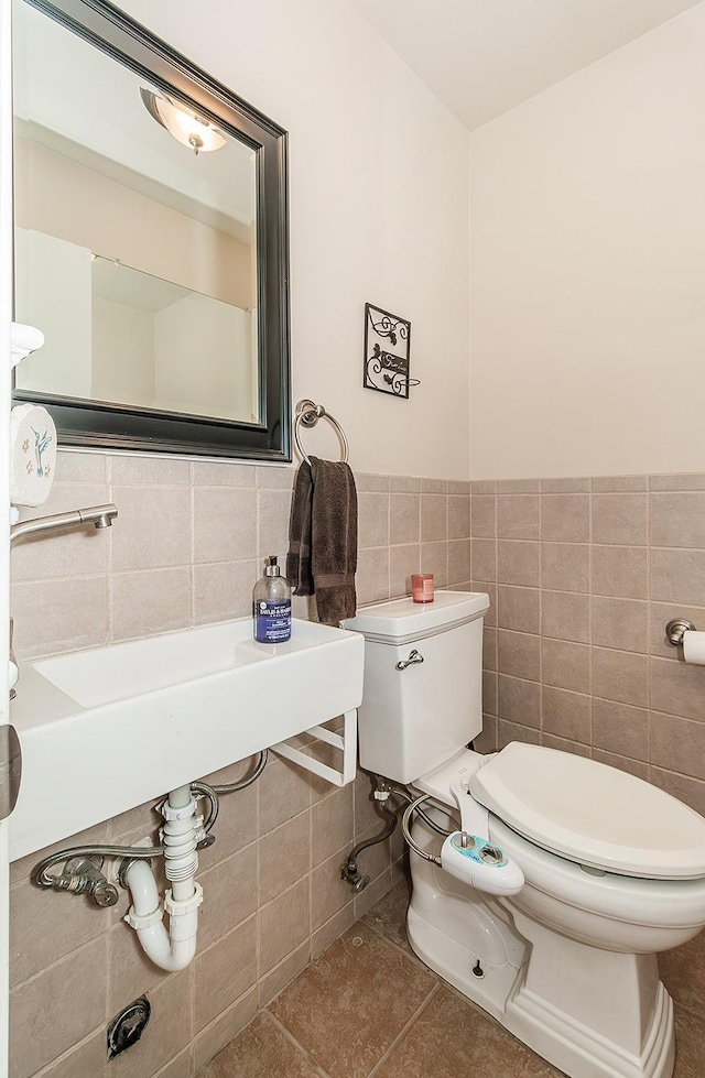 bathroom featuring tile walls, tile patterned flooring, and toilet