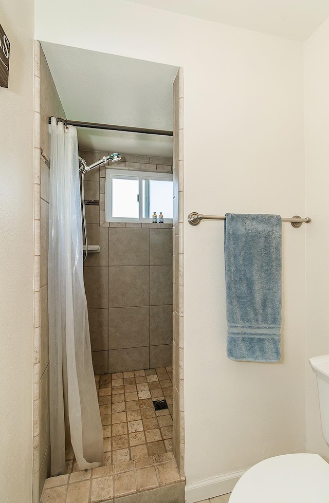 bathroom featuring walk in shower and toilet