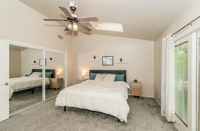 bedroom with carpet, a closet, ceiling fan, and vaulted ceiling with skylight