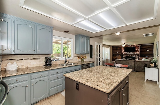 kitchen featuring ceiling fan, a brick fireplace, a kitchen island, sink, and built in features