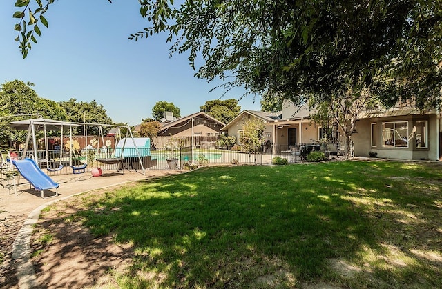 view of yard with a playground and a fenced in pool