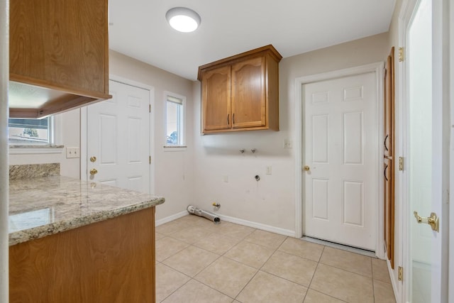 laundry area with hookup for a washing machine, cabinets, light tile patterned floors, and gas dryer hookup