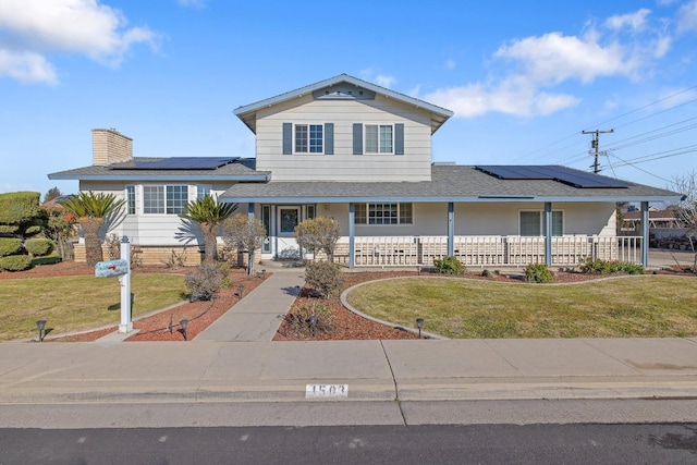 view of front of house featuring solar panels and a front yard