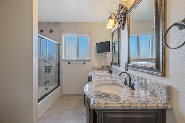 bathroom with combined bath / shower with glass door, tile patterned flooring, and vanity