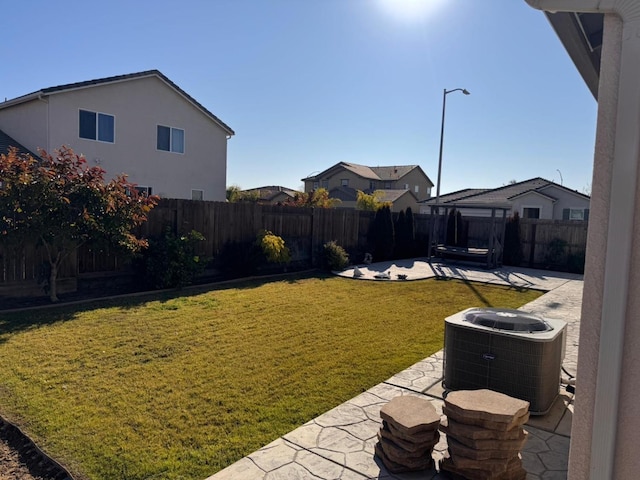 view of yard with central air condition unit and a patio area