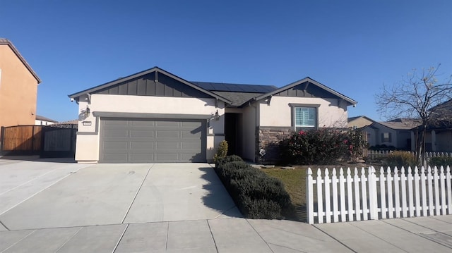 ranch-style home featuring a garage and solar panels