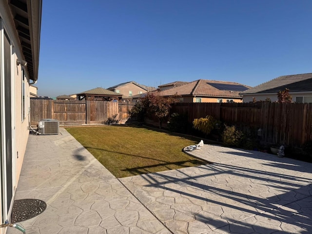 view of yard with central AC unit and a patio