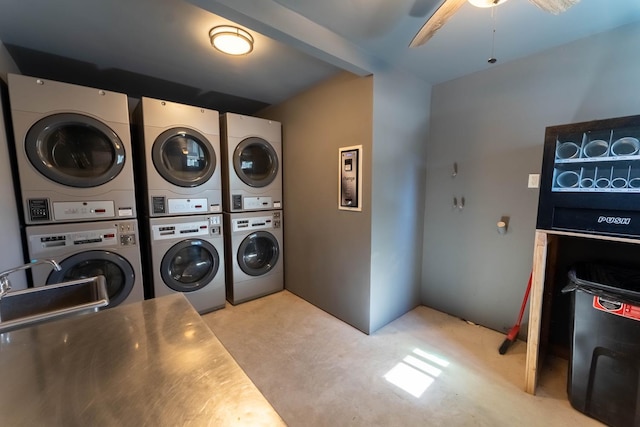 clothes washing area with sink, ceiling fan, and stacked washer and dryer