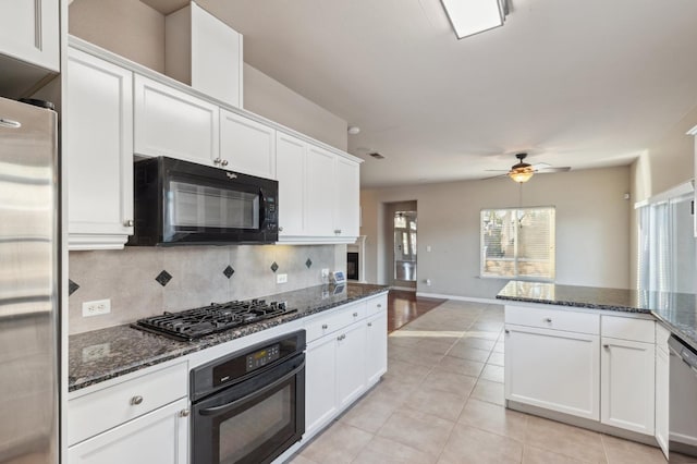 kitchen with black appliances, white cabinets, and dark stone countertops