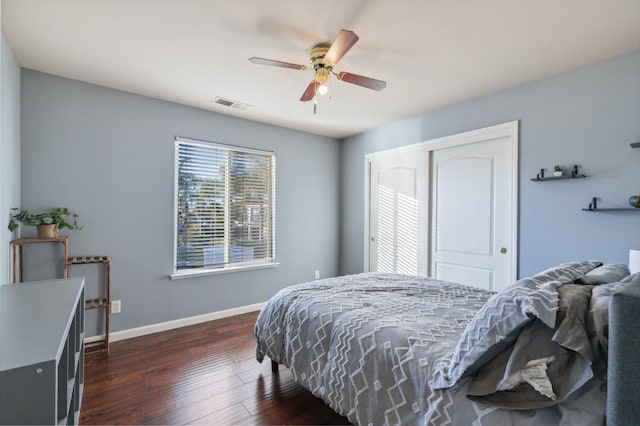 bedroom with dark hardwood / wood-style flooring, a closet, and ceiling fan