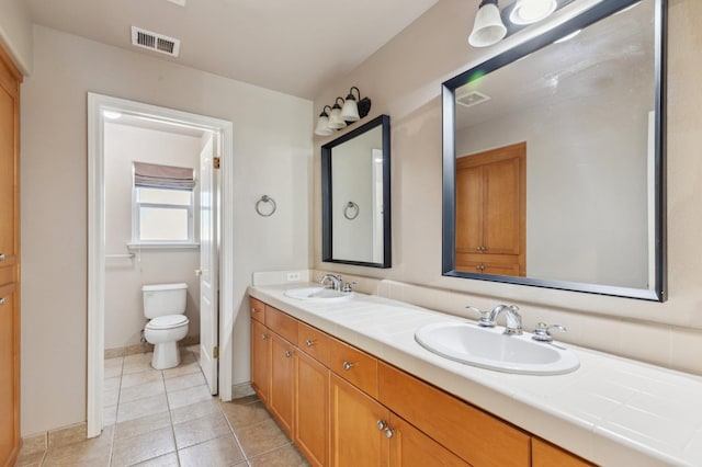 bathroom with toilet, tile patterned flooring, and vanity