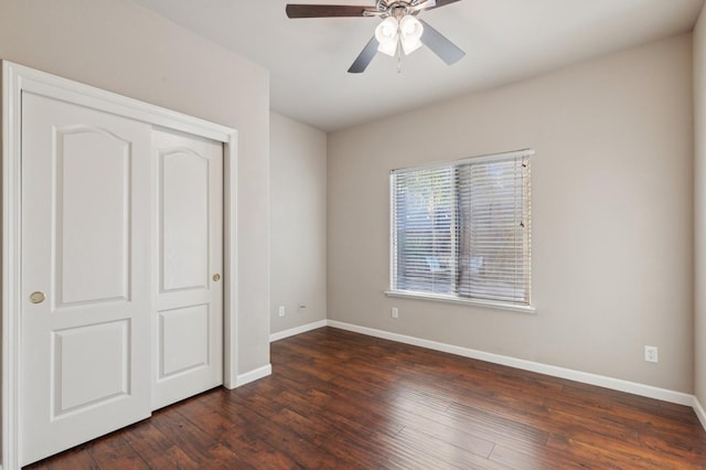 unfurnished bedroom with ceiling fan, a closet, and dark hardwood / wood-style floors