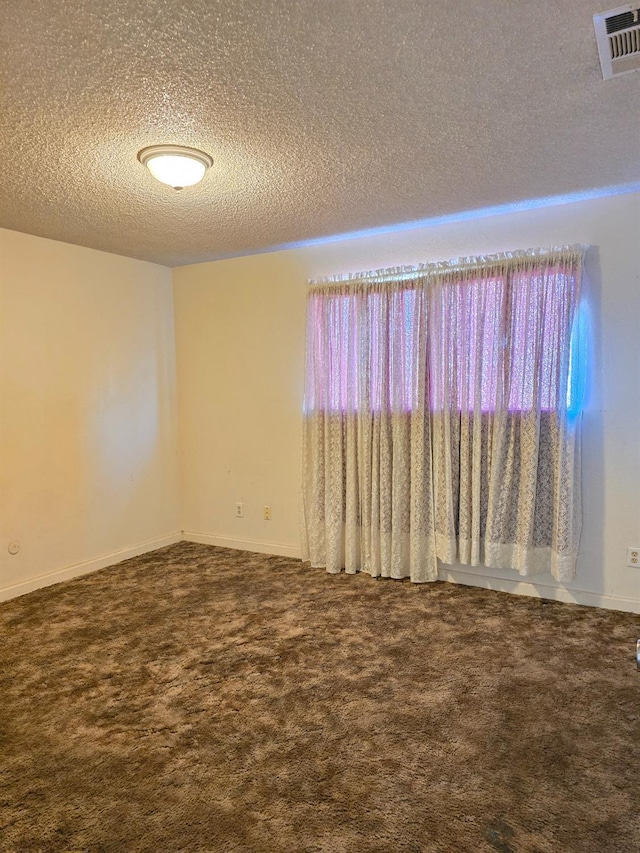 spare room featuring a textured ceiling and carpet floors