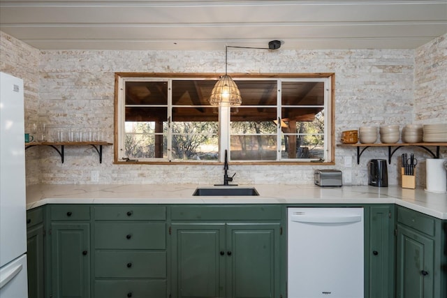 kitchen featuring white appliances, hanging light fixtures, green cabinetry, and sink