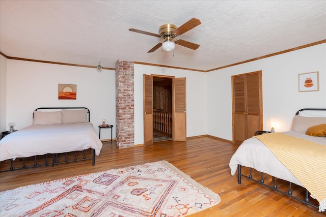 bedroom with ceiling fan, hardwood / wood-style floors, ornamental molding, and a textured ceiling