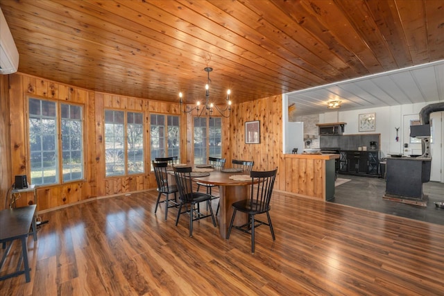 dining space with dark hardwood / wood-style flooring, an inviting chandelier, and wood ceiling