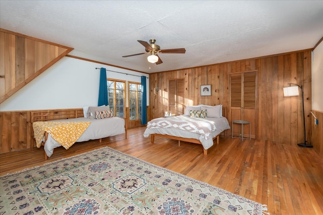 bedroom featuring wood-type flooring, ceiling fan, and crown molding