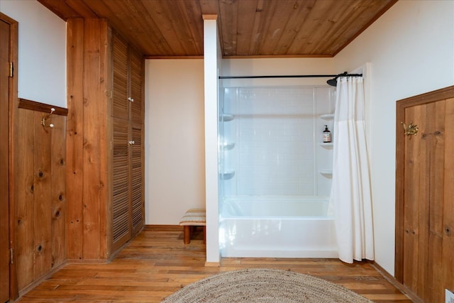 bathroom with shower / bathtub combination with curtain, wood ceiling, and hardwood / wood-style flooring