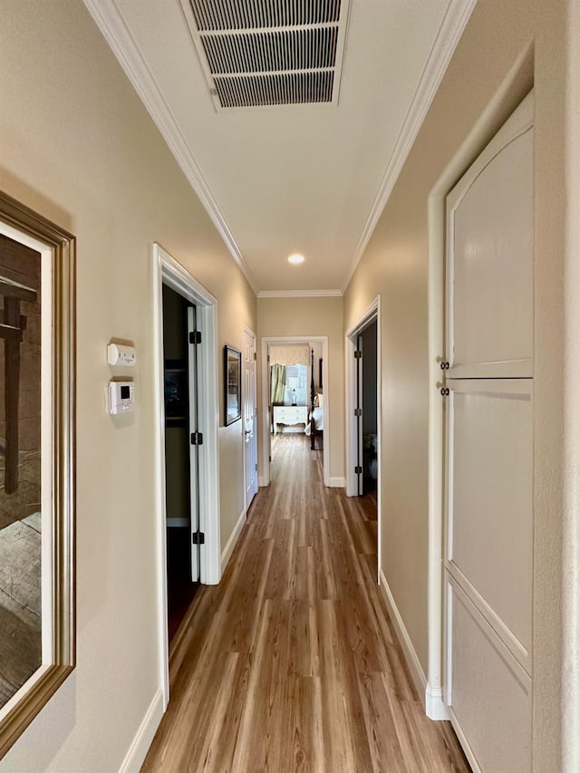 hall featuring light hardwood / wood-style floors and crown molding