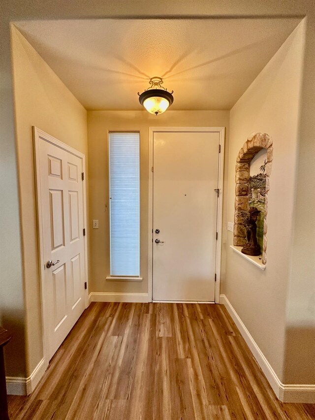 doorway to outside featuring a textured ceiling and hardwood / wood-style floors