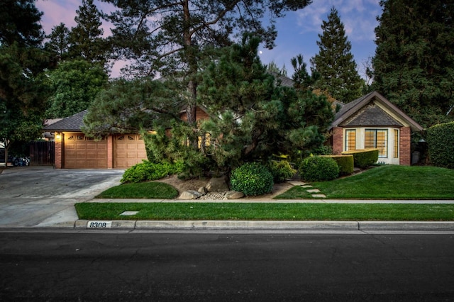 view of front of property with a garage and a lawn