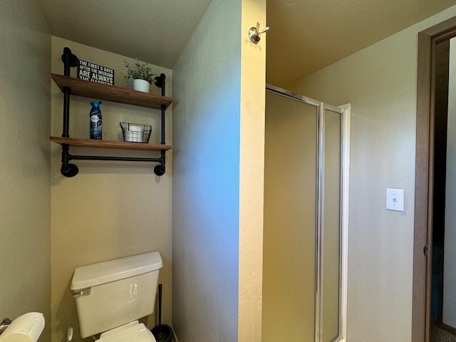 bathroom featuring toilet and an enclosed shower