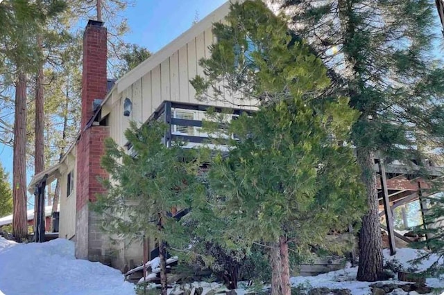 snow covered property with a chimney