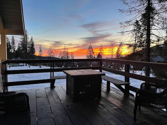 deck at dusk featuring a fire pit