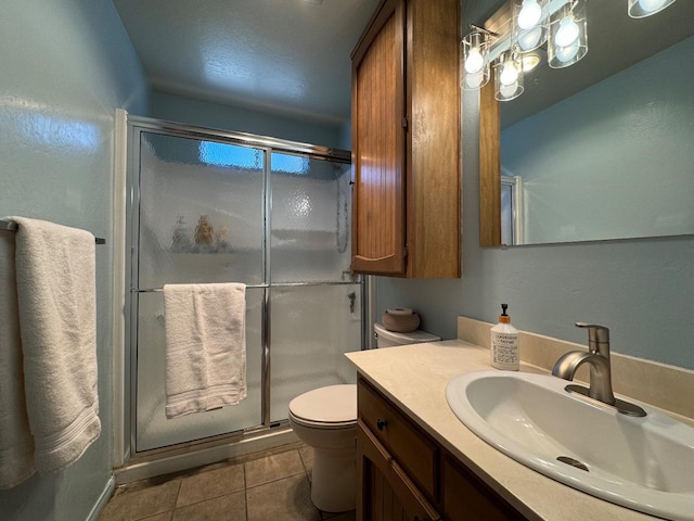 bathroom with vanity, toilet, tile patterned flooring, and a stall shower