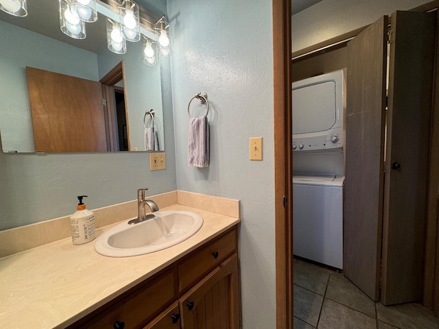 bathroom featuring tile patterned flooring, stacked washer / drying machine, and vanity