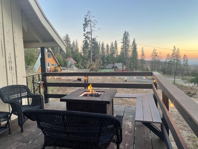 patio terrace at dusk with a deck and a fire pit